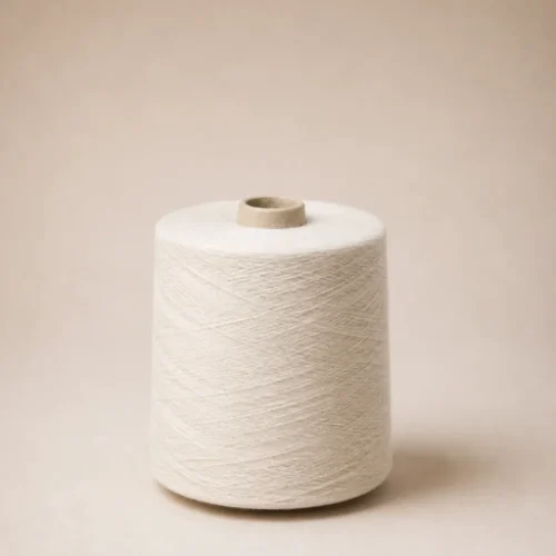 Cuộn sợi cotton open-end 100% màu trắng Cuộn sợi cotton open-end 100% màu trắng đặt thẳng trên nền be