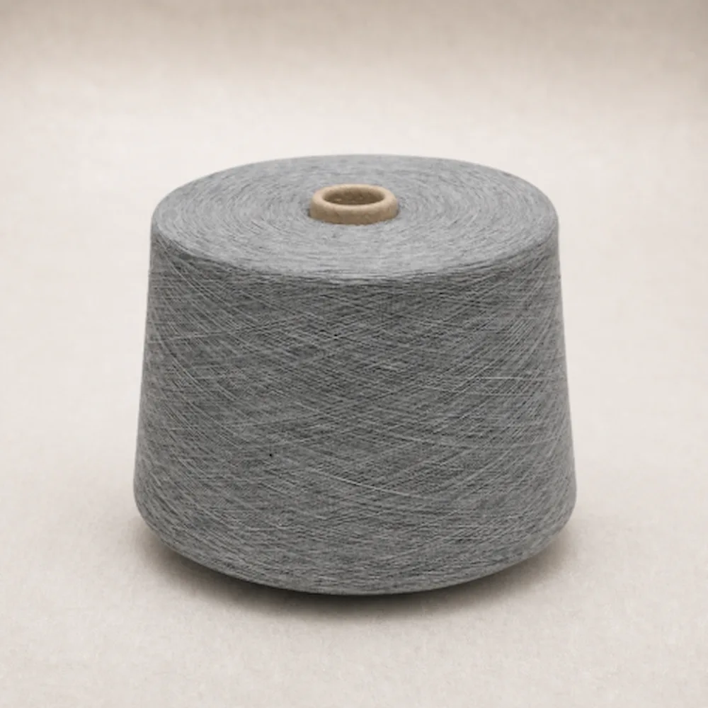 Ống sợi cotton melange chải kỹ màu xám đặt thẳng trên nền sáng