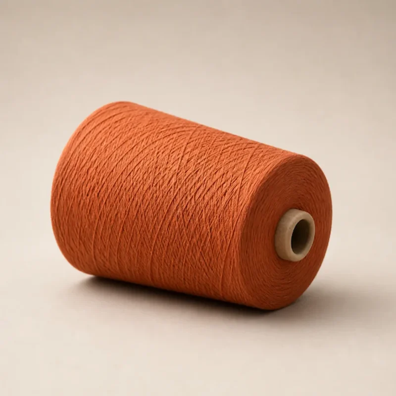 Sợi bamboo Ne 32/2 màu cam quấn cone Côn sợi bamboo Ne 32/2 màu cam đặt nằm trên nền sáng