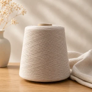 Sợi cotton 100% màu trắng ngà dạng cone Côn sợi cotton 100% màu trắng ngà đặt trên mặt bàn gỗ