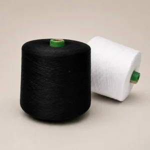 Sợi cotton chải kỹ 100% Ne 8s màu đen và trắng Hai cuộn sợi cotton chải kỹ 100% Ne 8s màu đen và trắng trên nền xám ấm.