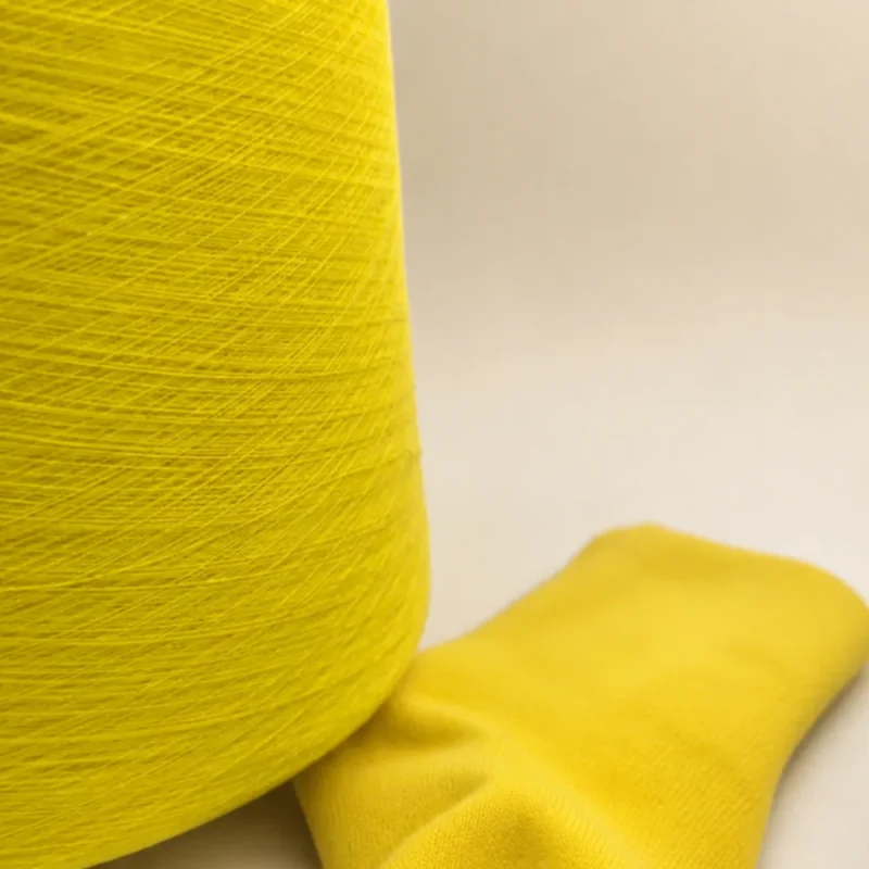 Sợi cotton chải thô màu vàng dùng cho vớ Cone sợi cotton màu vàng đặt cạnh vớ dệt kim màu vàng