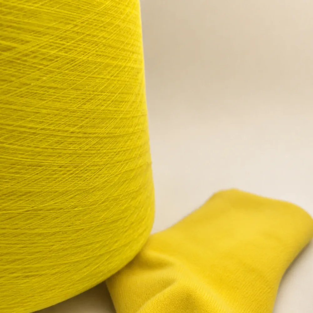 Cone sợi cotton màu vàng đặt cạnh vớ dệt kim màu vàng