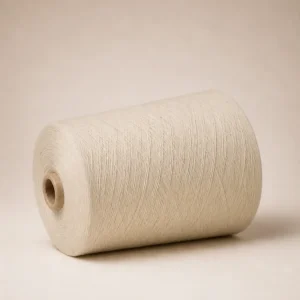 Sợi cotton open-end màu trắng dạng cuộn côn Cuộn sợi cotton open-end màu trắng nằm ngang, lộ rõ lõi giấy