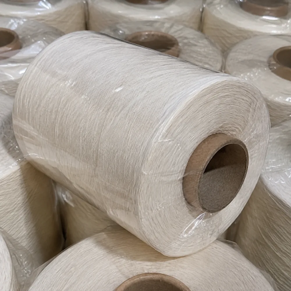 Cận cảnh một cone sợi cotton BCI chải kỹ được bọc màng bảo vệ