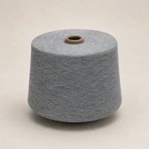 Cuộn sợi melange cotton ring spun màu xám Cuộn sợi melange cotton ring spun màu xám đặt đứng trên nền sáng