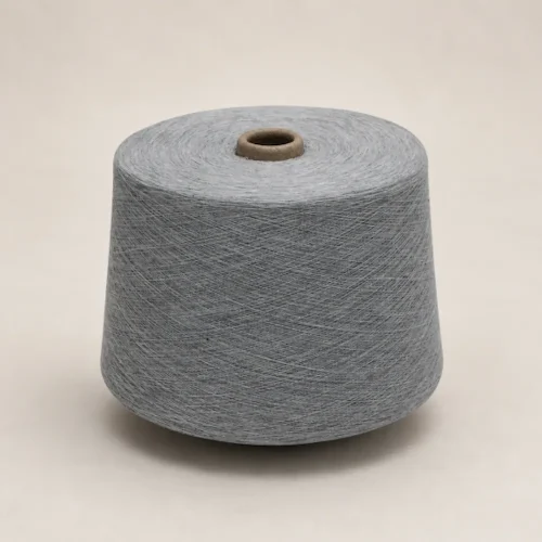 Cuộn sợi melange cotton ring spun màu xám Cuộn sợi melange cotton ring spun màu xám đặt đứng trên nền sáng