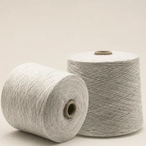 Hai cuộn sợi melange cotton tông xám sáng Hai cuộn sợi melange cotton màu xám sáng, một cuộn đứng và một cuộn nằm