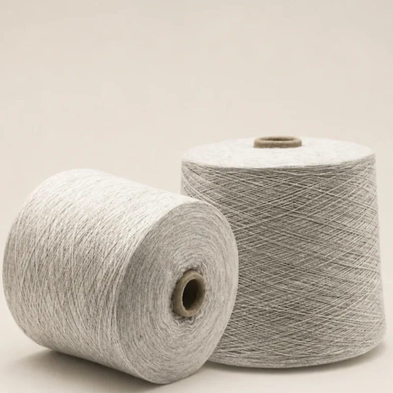 Hai cuộn sợi melange cotton tông xám sáng Hai cuộn sợi melange cotton màu xám sáng, một cuộn đứng và một cuộn nằm