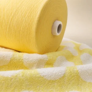 Sợi Cotton Ne 80/2 Cho Dệt Khăn Cuộn sợi cotton Ne 80/2 màu vàng nhạt đặt trên khăn dệt kim