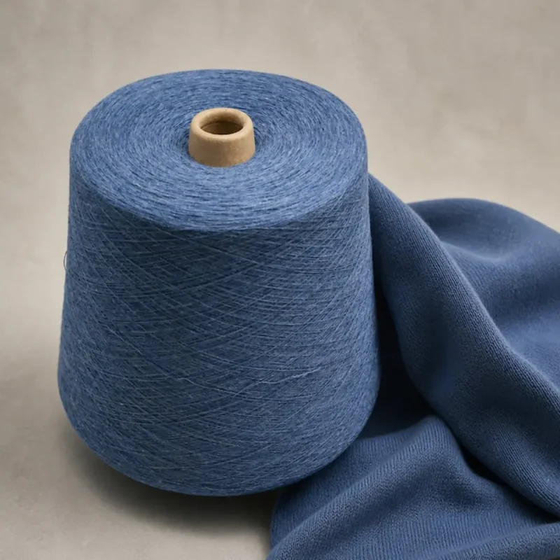 Sợi cotton melange 100% và vải dệt tất Sợi cotton melange 100% đặt cạnh vải dệt màu xanh dùng cho tất