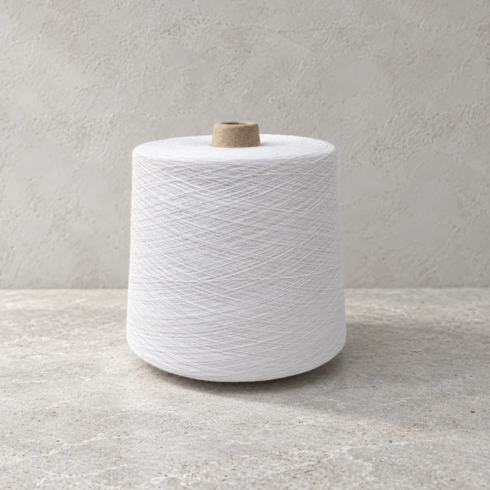 Cone sợi trắng dựng đứng trên mặt bàn xám