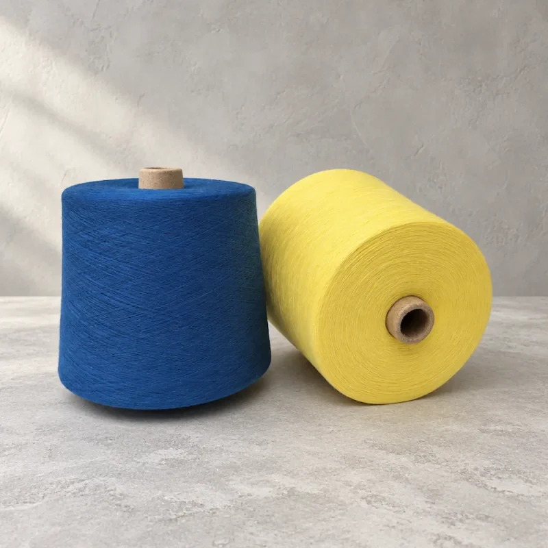Hai cone sợi màu xanh dương và vàng Cone sợi xanh dương dựng đứng cạnh cone sợi vàng đặt nằm ngang