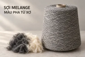 Cuộn sợi melange xám bên cạnh xơ đen và xơ trắng