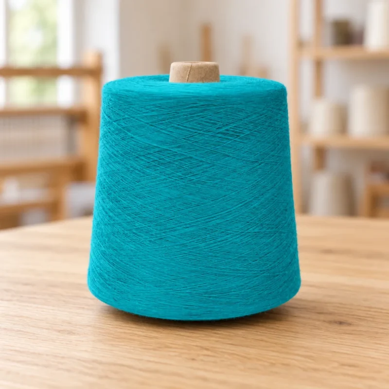 Cone sợi cotton tái chế 8S/1 màu xanh cyan dạng đứng trên mặt gỗ.