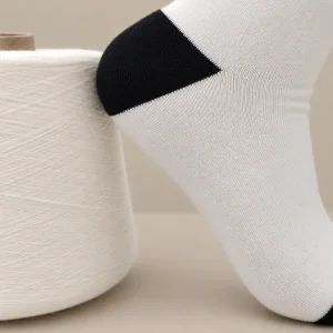 Tất dệt kim trắng đen đặt cạnh cuộn sợi tre màu trắng