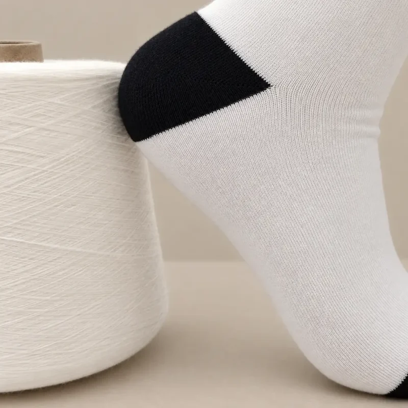 Tất dệt kim trắng đen đặt cạnh cuộn sợi tre màu trắng